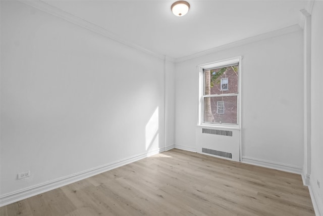 unfurnished room with baseboards, crown molding, light wood finished floors, and radiator heating unit