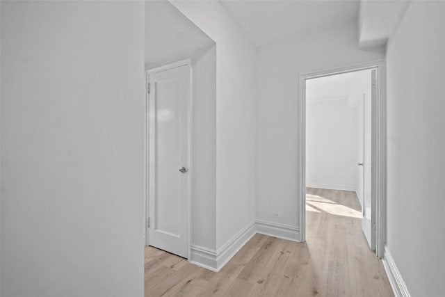 hall with light wood finished floors and baseboards