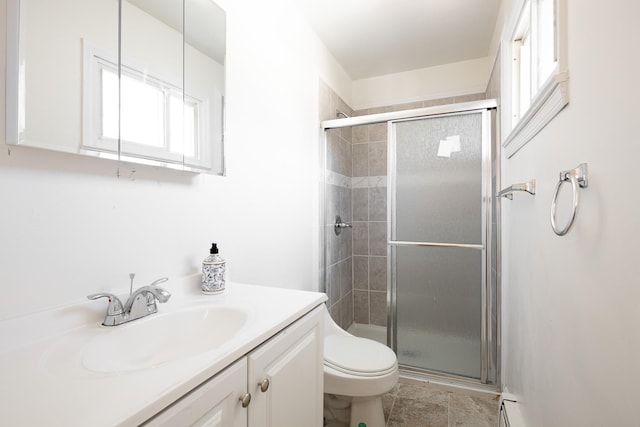 full bath featuring a stall shower, a baseboard radiator, vanity, and toilet