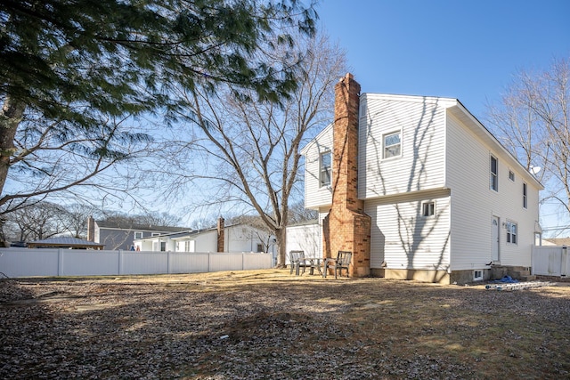 rear view of property with fence and a chimney