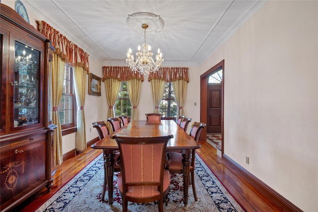 dining space with an inviting chandelier, crown molding, and hardwood / wood-style flooring