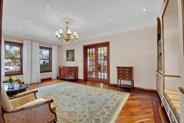 sitting room with baseboards, ornamental molding, wood finished floors, and french doors