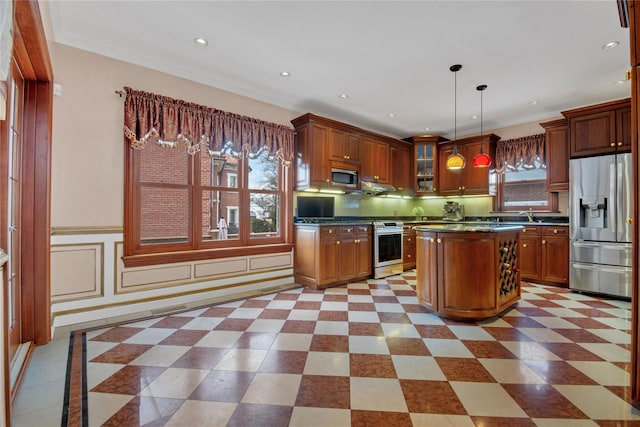 kitchen featuring appliances with stainless steel finishes, dark countertops, a wealth of natural light, and pendant lighting