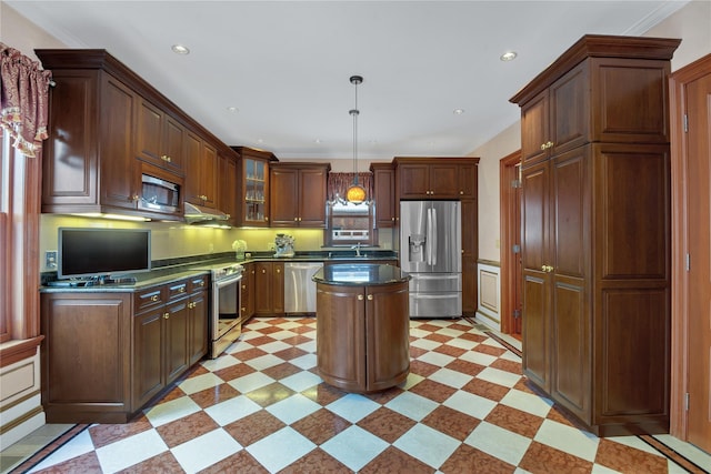 kitchen with dark countertops, appliances with stainless steel finishes, glass insert cabinets, decorative light fixtures, and light floors