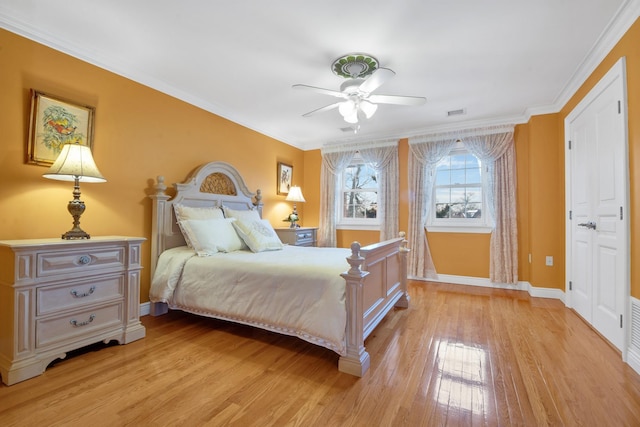 bedroom featuring ornamental molding, light wood finished floors, and baseboards