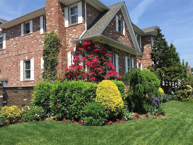 view of side of home with a yard and brick siding