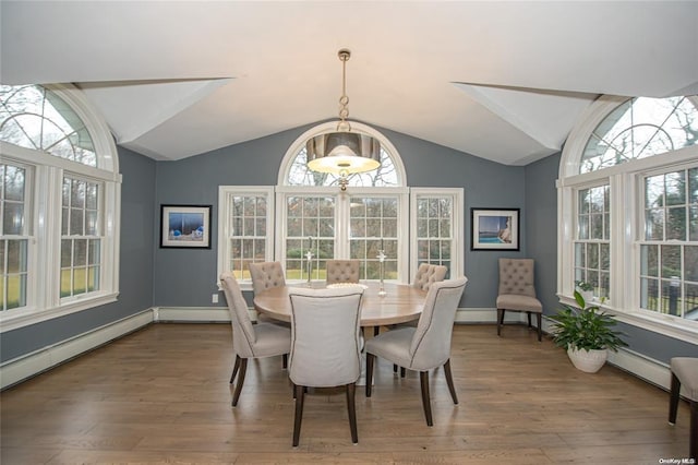 dining area with vaulted ceiling, baseboards, and wood finished floors