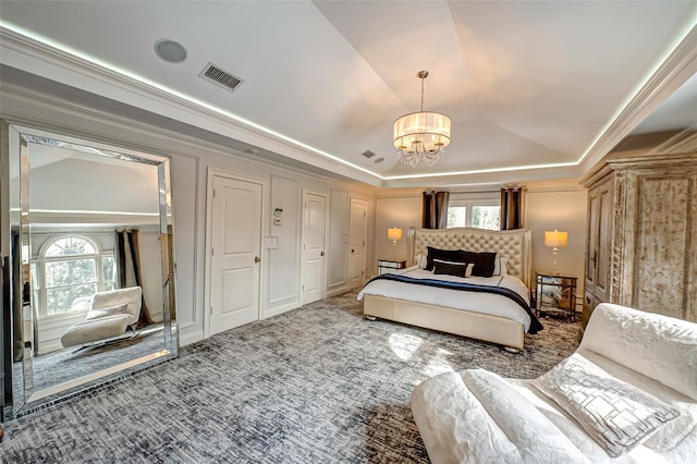 bedroom with visible vents, multiple windows, a tray ceiling, and dark colored carpet