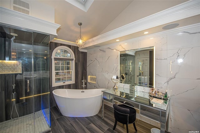 bathroom featuring vaulted ceiling with skylight, a marble finish shower, visible vents, a soaking tub, and tile walls