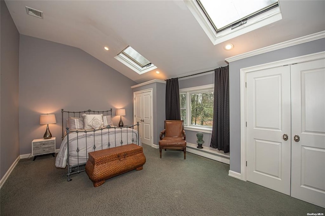 bedroom with a baseboard heating unit, lofted ceiling with skylight, dark carpet, and visible vents