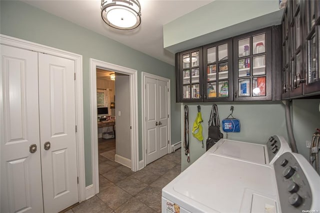 laundry area featuring independent washer and dryer, cabinet space, and baseboards