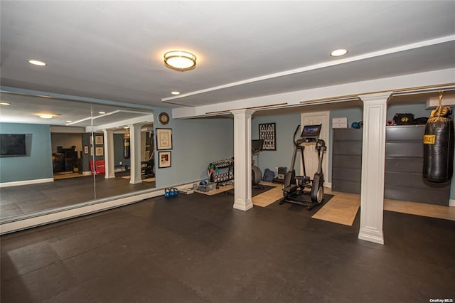 exercise room featuring baseboards, recessed lighting, and ornate columns