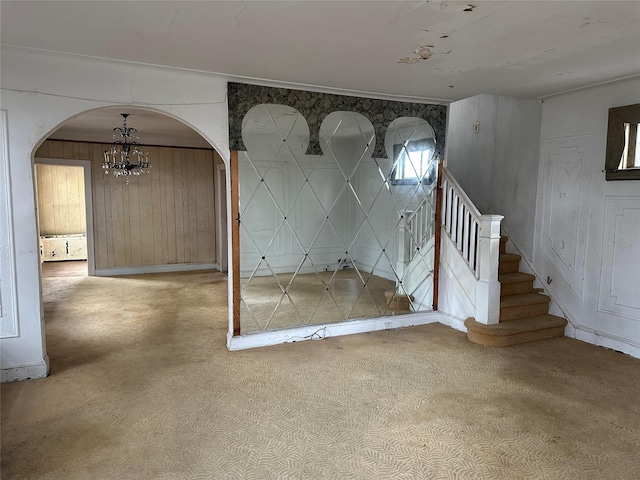 interior space featuring stairway, arched walkways, and a notable chandelier