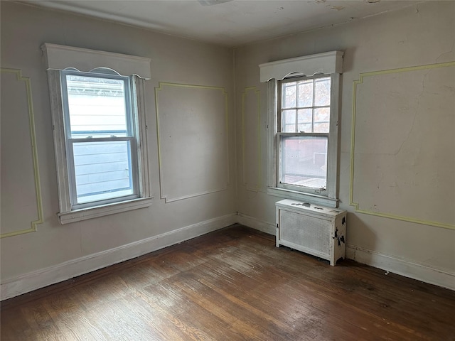 empty room with baseboards and dark wood finished floors