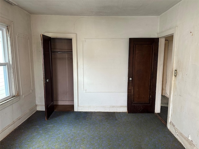 unfurnished bedroom featuring dark carpet