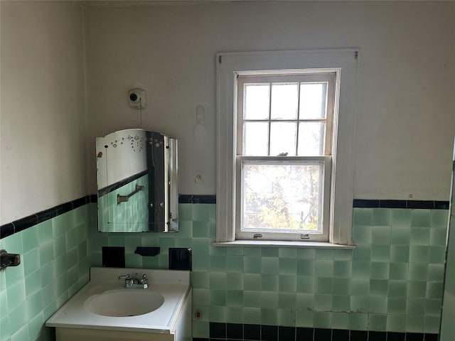 bathroom featuring tile walls, wainscoting, and vanity