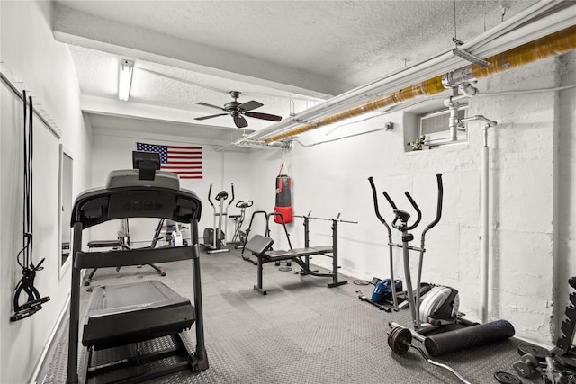 workout room with a wall mounted air conditioner, ceiling fan, and a textured ceiling