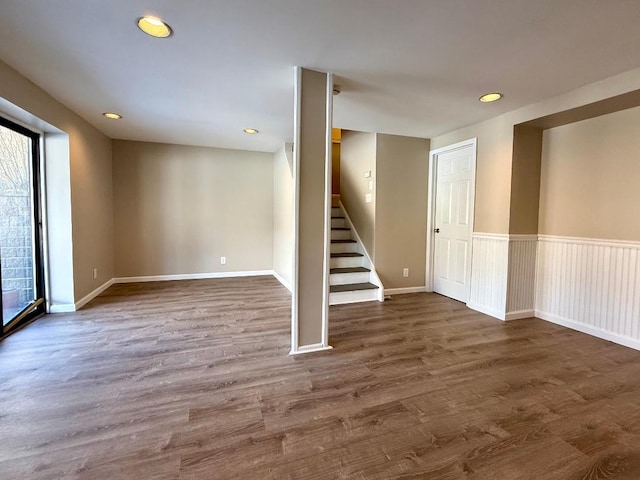 unfurnished room with baseboards, dark wood-style floors, a wainscoted wall, stairs, and recessed lighting