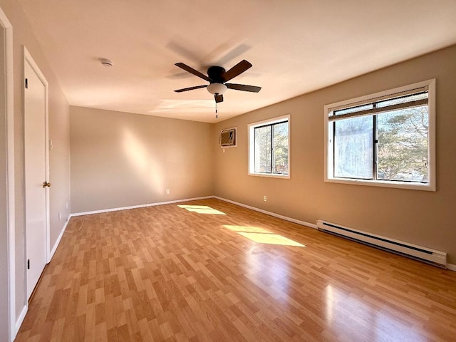 spare room with light wood-type flooring, baseboards, a baseboard heating unit, and ceiling fan