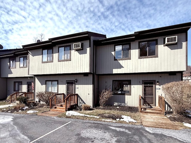 townhome / multi-family property with a wall unit AC