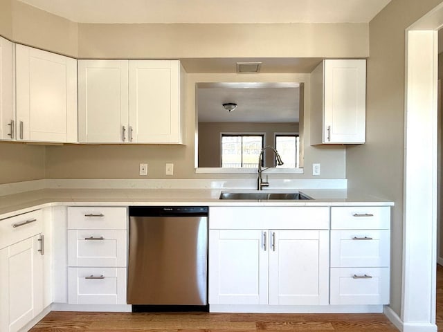 kitchen featuring visible vents, white cabinets, light countertops, stainless steel dishwasher, and a sink