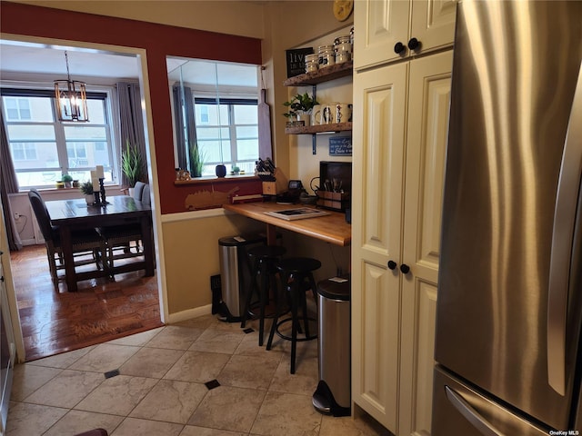 kitchen featuring open shelves, light countertops, hanging light fixtures, freestanding refrigerator, and a chandelier