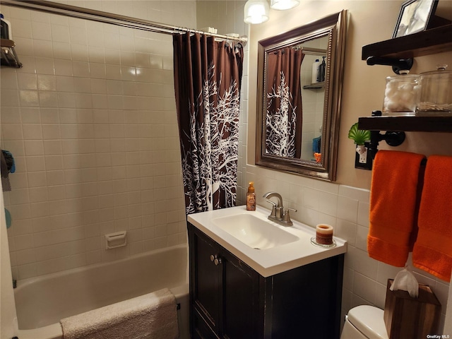 full bathroom with shower / bath combo, toilet, tile walls, and vanity