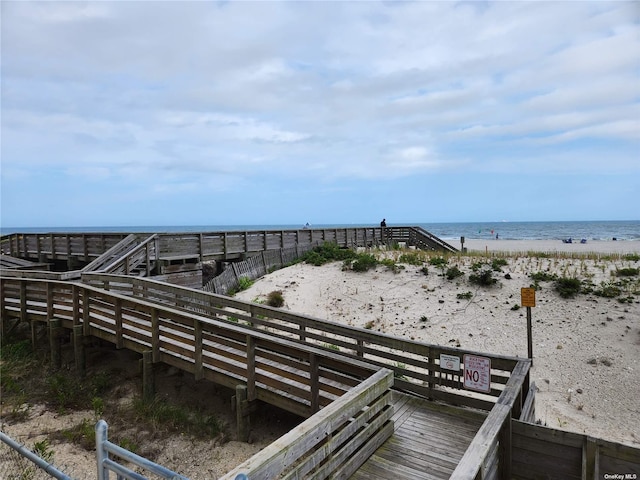 view of home's community featuring a water view and a beach view