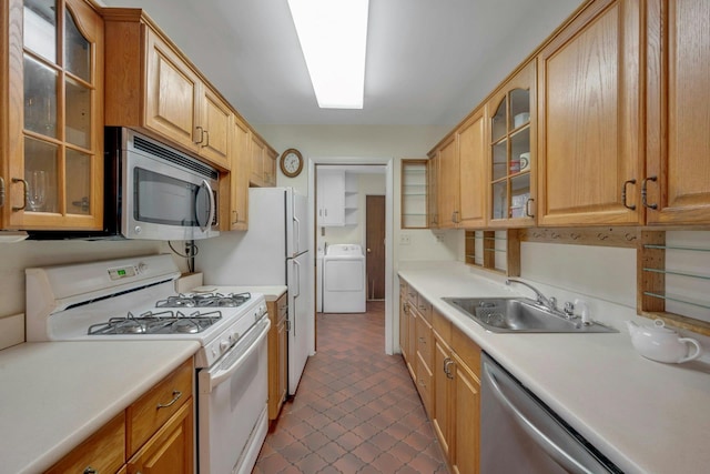 kitchen featuring appliances with stainless steel finishes, washer / clothes dryer, a sink, and light countertops