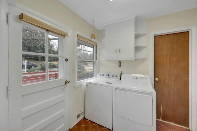 laundry area featuring cabinet space, independent washer and dryer, and visible vents