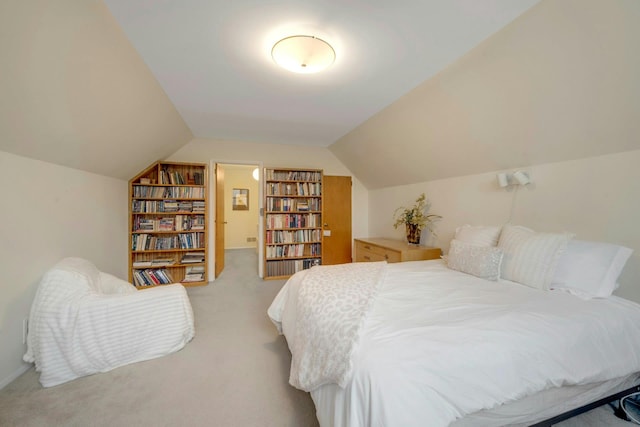 bedroom featuring light carpet and vaulted ceiling