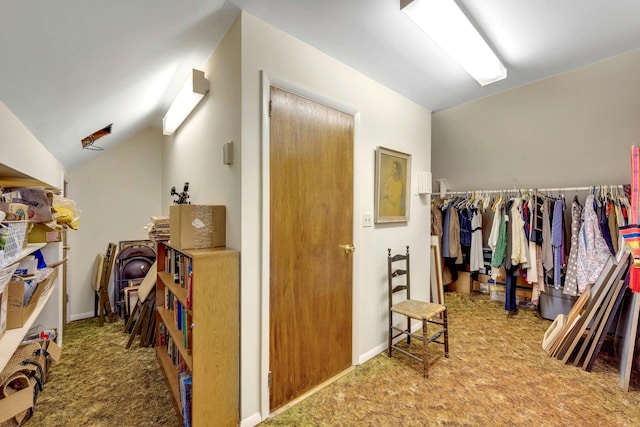 interior space featuring vaulted ceiling, carpet flooring, and baseboards