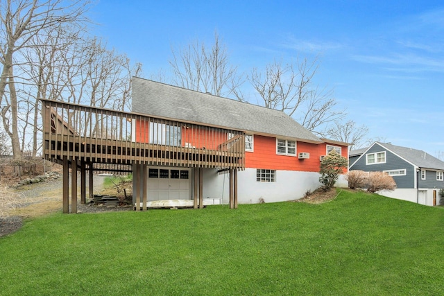 rear view of property featuring a shingled roof, a lawn, and a wooden deck