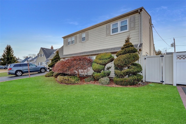 view of front of home featuring a front yard, a gate, and fence