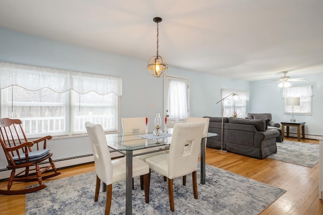 dining room featuring a baseboard radiator and light wood finished floors