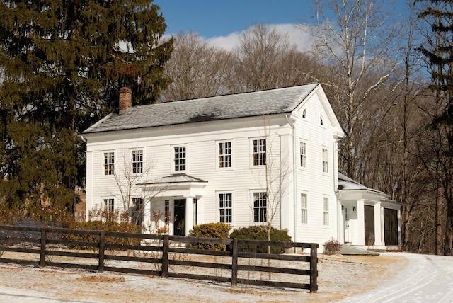 view of front of house featuring a fenced front yard and a chimney