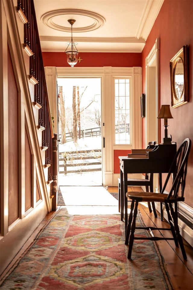 entryway with stairs, ornamental molding, and a notable chandelier