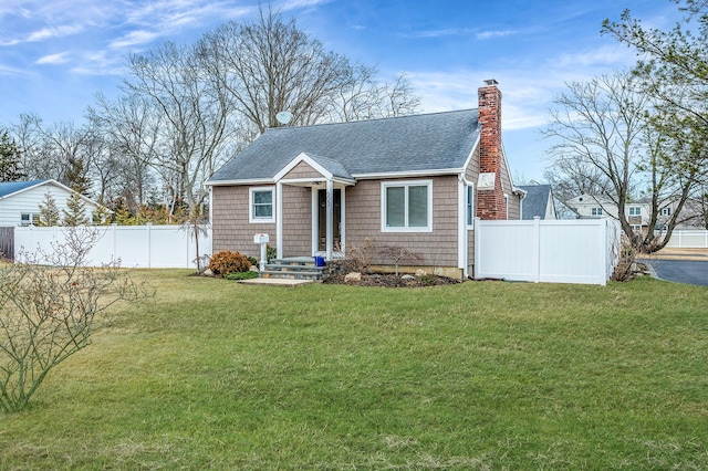 view of front of home featuring a shingled roof, a front yard, fence, and a chimney