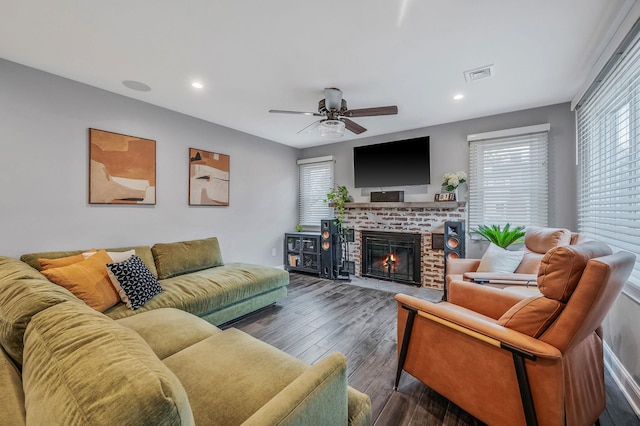 living room featuring recessed lighting, visible vents, a ceiling fan, a brick fireplace, and wood finished floors