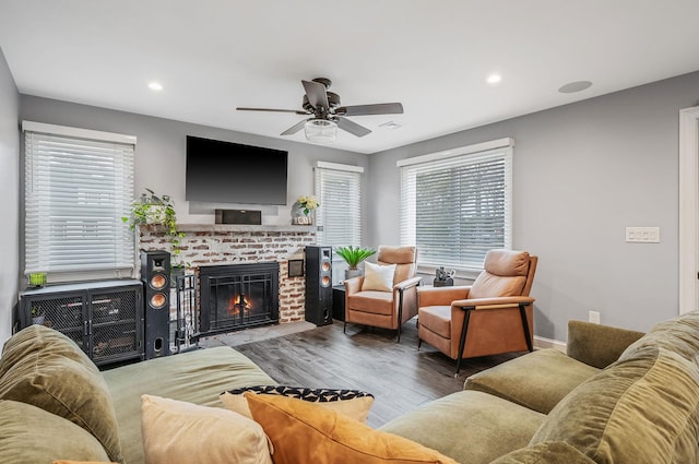 living room with a brick fireplace, a ceiling fan, wood finished floors, and recessed lighting