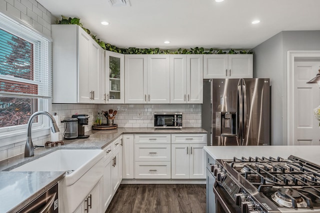 kitchen featuring appliances with stainless steel finishes, white cabinets, and a sink