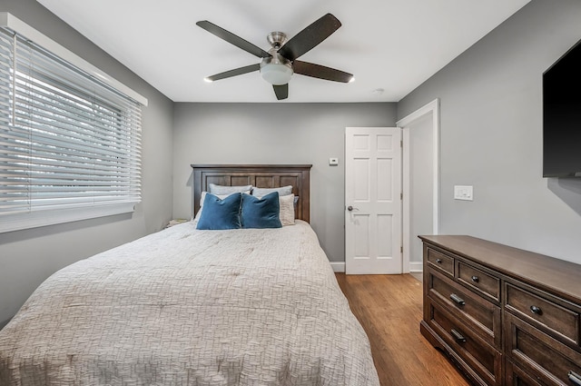 bedroom featuring wood finished floors, a ceiling fan, and baseboards