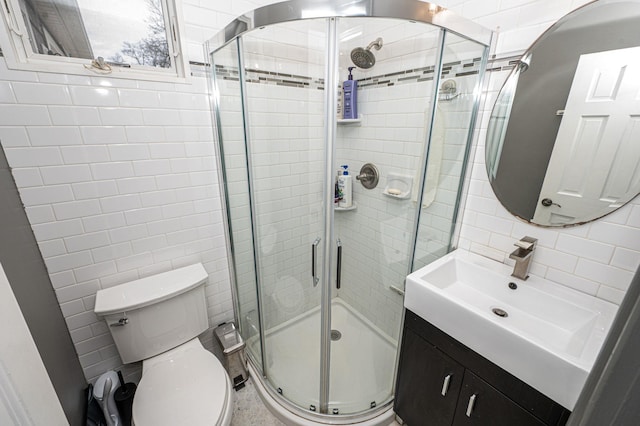 full bathroom with backsplash, tile walls, a shower stall, and vanity