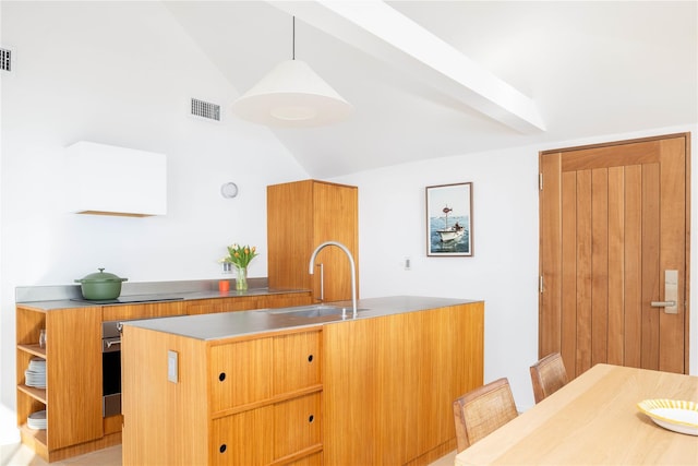 kitchen featuring a center island with sink, stainless steel countertops, visible vents, hanging light fixtures, and a sink