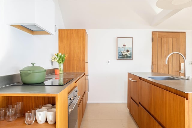 kitchen featuring light countertops, brown cabinetry, a sink, modern cabinets, and oven