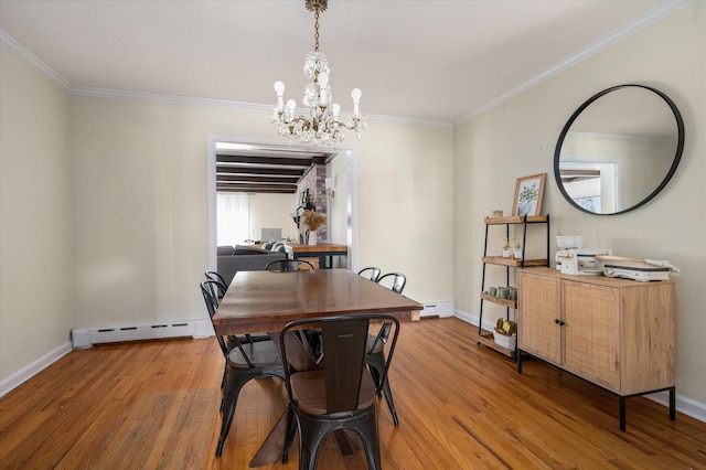 dining space with crown molding, a notable chandelier, baseboard heating, light wood-type flooring, and baseboards