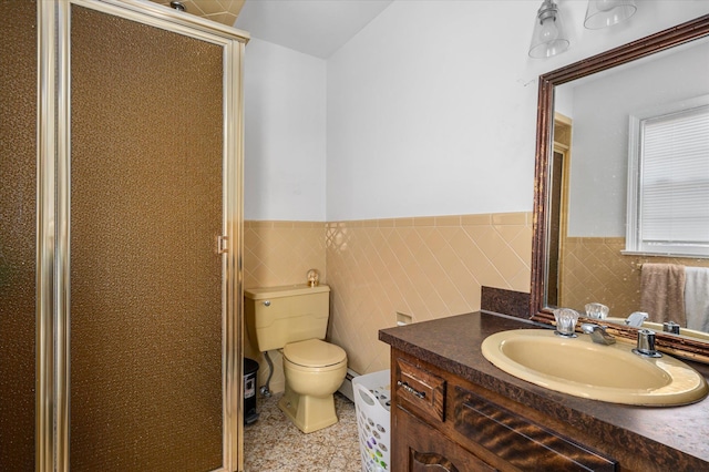 full bathroom with toilet, a stall shower, a wainscoted wall, and vanity