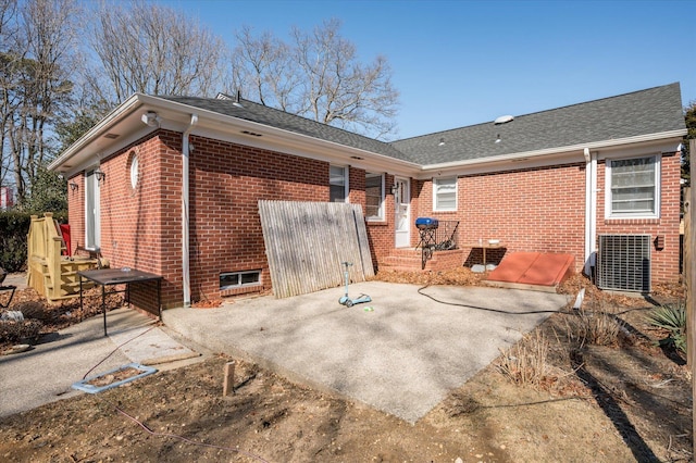 rear view of house with a shingled roof and brick siding