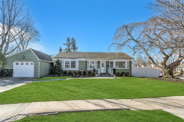 view of front of property with a front yard, concrete driveway, fence, and a chimney