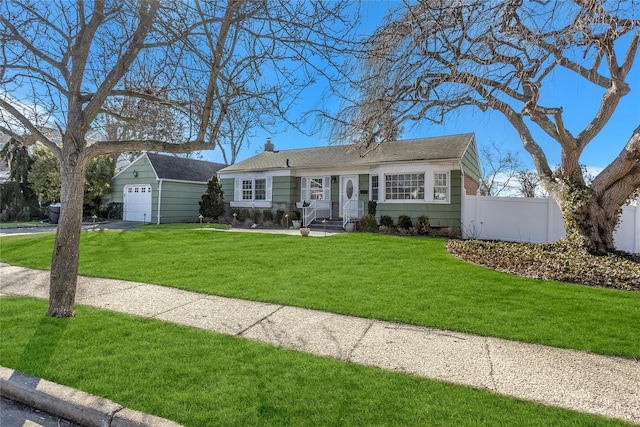 view of front of property featuring driveway, a chimney, an outbuilding, fence, and a front yard